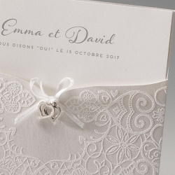 Détails de la pochette de faire-part mariage avec fins motifs en suédine blanche